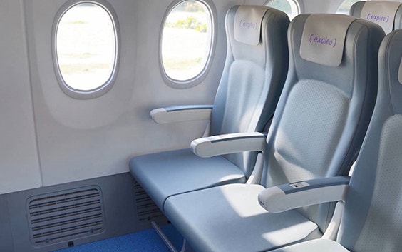Dreierreihe von Sitzen in einem Flugzeug mit sichtbarem Sockel an der Seitenwand