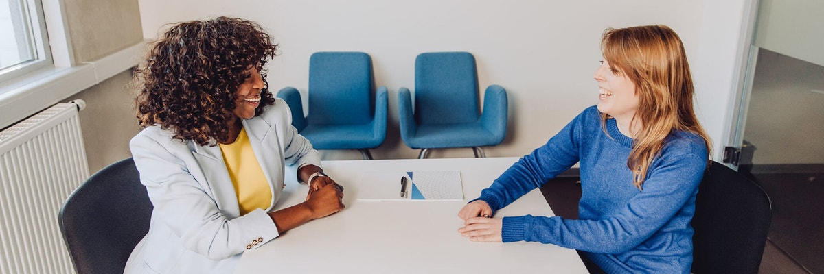 An HR professional and prospective employee sitting at a table, discussing a contract