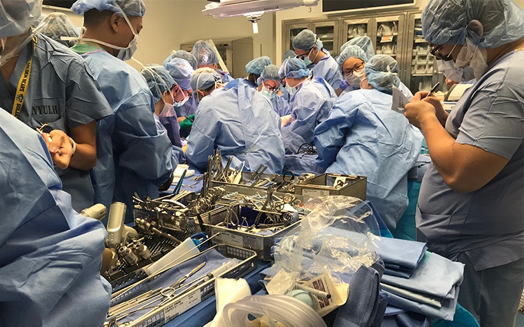 Group of people in surgical gear in an operating theater