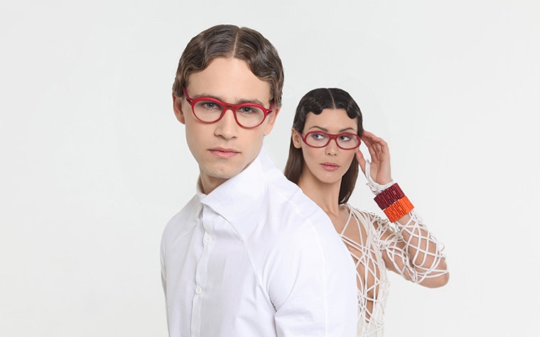 Modelos masculino y femenino con gafas rojas de la colección Yuniku Hoet