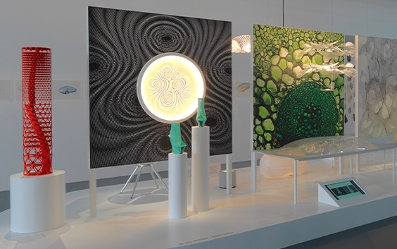 Various art installations, including a red, dotted, cylindrical model, a lit orb, and paintings