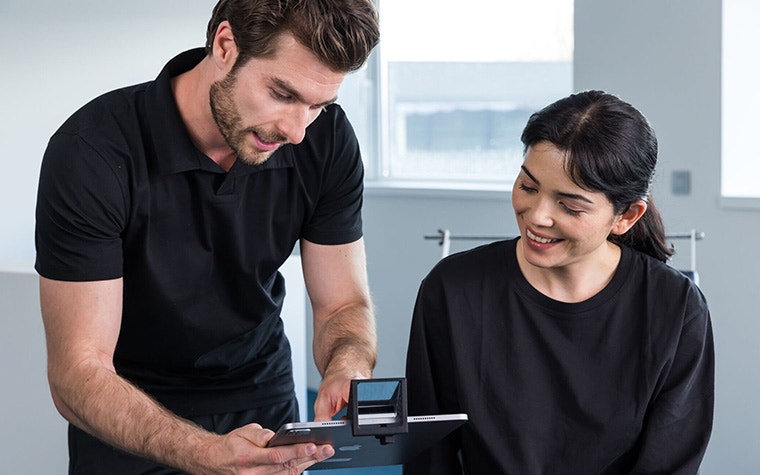 A man and a woman in a clinic looking at an iPad featuring the Materialise SAM mirror.