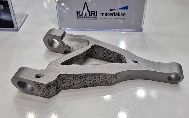 Triangular metal 3D-printed aerospace part with lattice structure on display. 