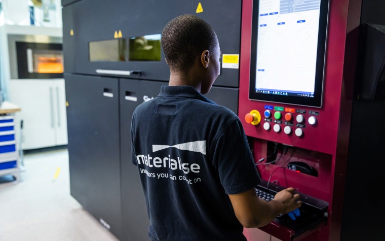 Ein Mitglied des Materialise-Produktionsteams bei der Überprüfung eines Bildschirms auf einem 3D-Drucker