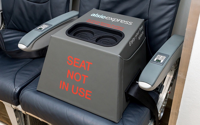 Bloqueador de asiento en forma de cubo de Stirling Dynamic, con cuero gris/verde hecho a mano y un inserto negro impreso en 3D en la parte superior para teléfonos inteligentes y otros dispositivos. Las palabras "Asiento no utilizado" están escritas en letras rojas en negrita en la cara frontal.