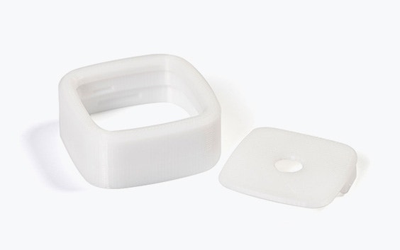 Un quadrato bianco e un coperchio stampati in 3D in PC-ISO utilizzando la modellazione a deposizione fusa.