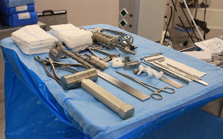 3D-printed knee guides along with surgical tools in the OR