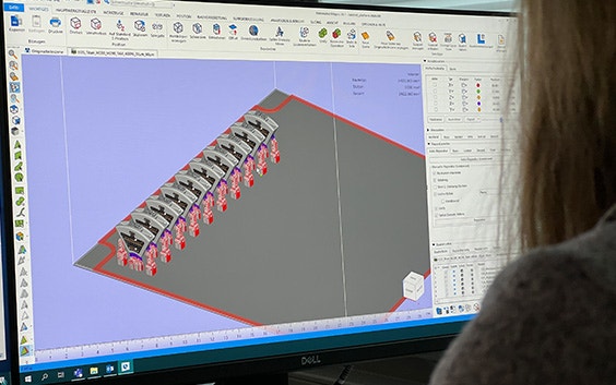 View over the shoulder of a woman using Materialise Magics software to label parts
