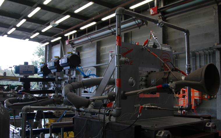 A 3D-printed rocket engine sits in a metal frame, ready for testing.