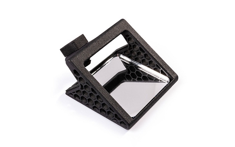 A small, black, 3D-printed mirror attachment for iOS devices.