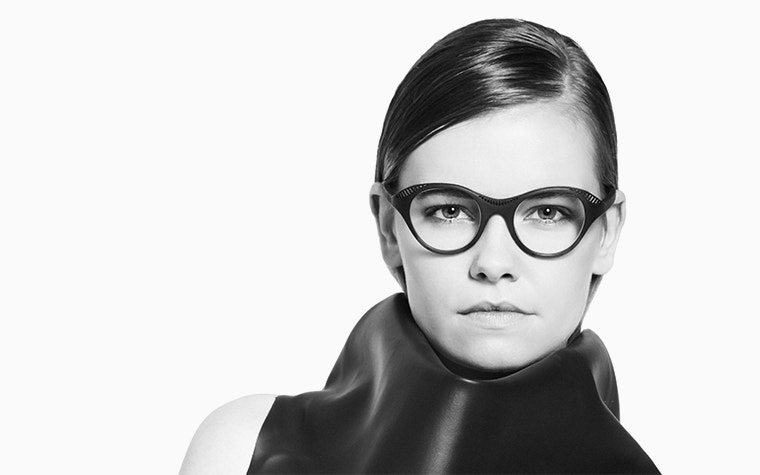 Imagen en escala de grises, en primer plano, de una modelo femenina con gafas negras Hoet Cabrio