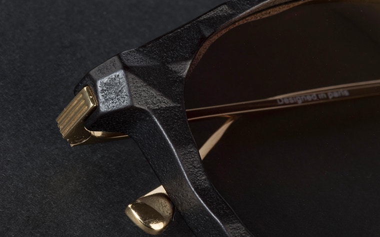 Close up of the hinge of the black and gold IMPRESSIO Vortex sunglasses