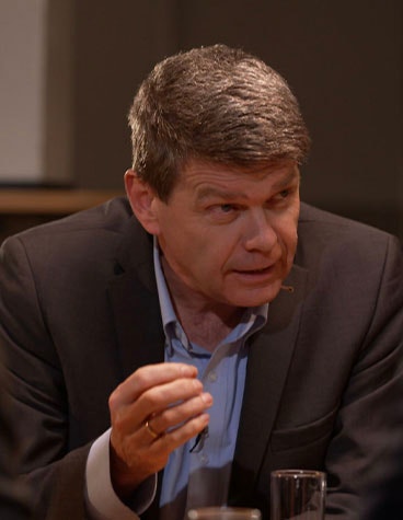 Peter Leys sitting at a table and speaking