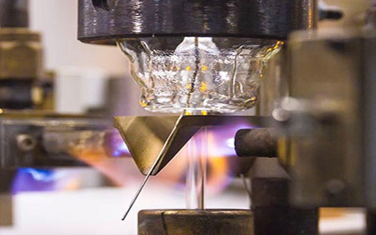 Close-up view of the lightbulb prodution line, with a flame heating up a component