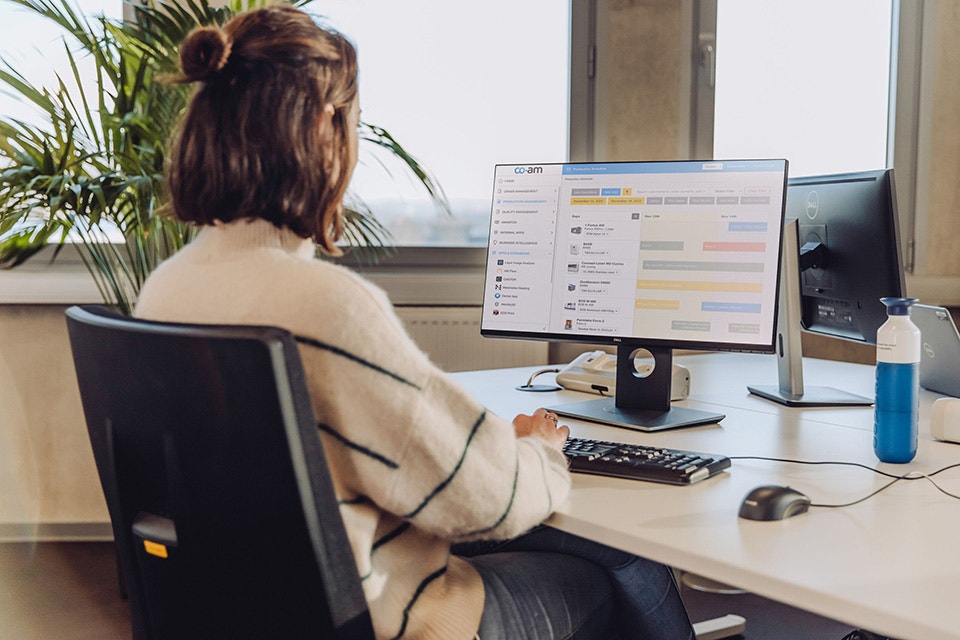 Femme assise à un bureau utilisant le logiciel Materialise