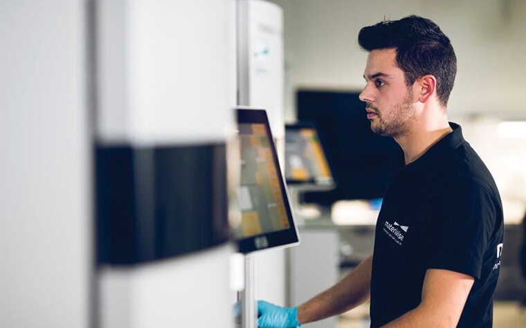 Man using a screen connected to a 3D printer in a production environment