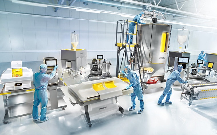 Sartorius employees in protective gear work with medtech machinery.