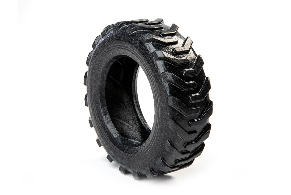 Black toy tractor wheel printed using Multi Jet Fusion, with a glossy surface