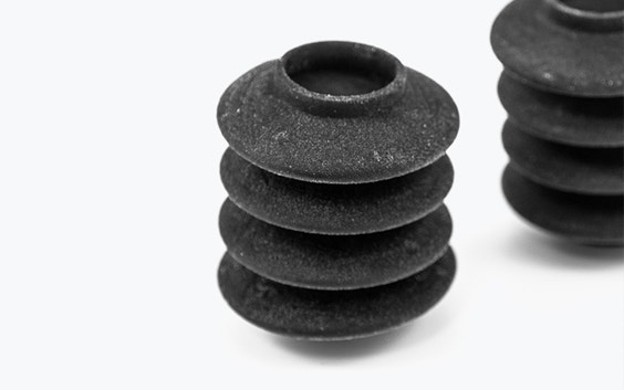 Detalle de dos fuelles negros impresos en 3D hechos de Agilus utilizando PolyJet