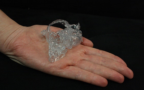 Modelo de corazón impreso en 3D sentado en la palma de una mano