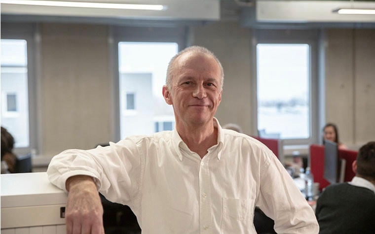 Quality Engineer Eddy Couvreur smiling in a busy office