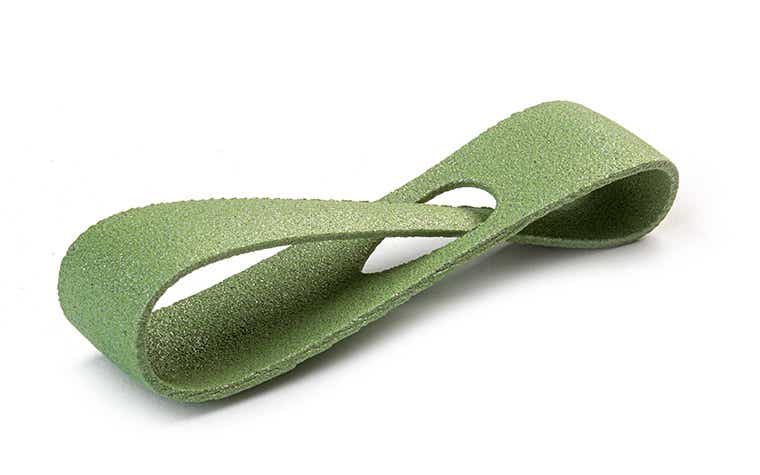 Un lazo verde brillante impreso en 3D hecho de PA-AF (relleno de aluminio) mediante sinterización por láser, con un acabado teñido de color.