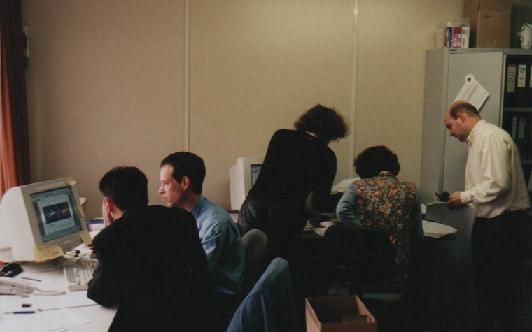 A group of people in an office using old desktop PCs