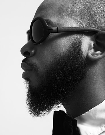 Gray-scale, side view of the face of a black male model wearing Hoet Cabrio sunglasses
