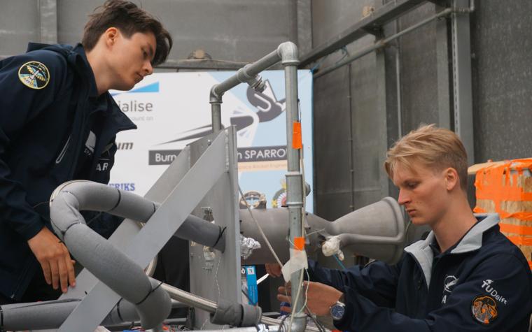 Two engineering students from TU Delft work on their 3D-printed rocket engine.