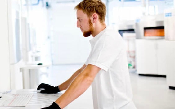 Man in a 3D printing production facility, using a computer