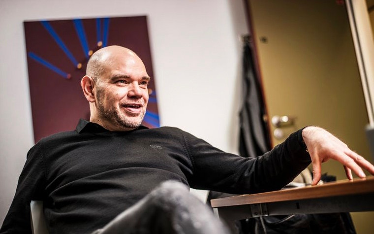 Stefaan de Nijs sitting down with his hand on a table