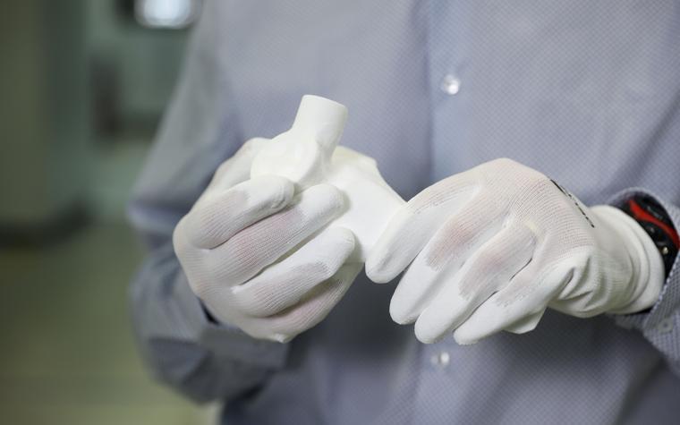 Person holding a 3D-printed part for a non-invasive PEEP mask