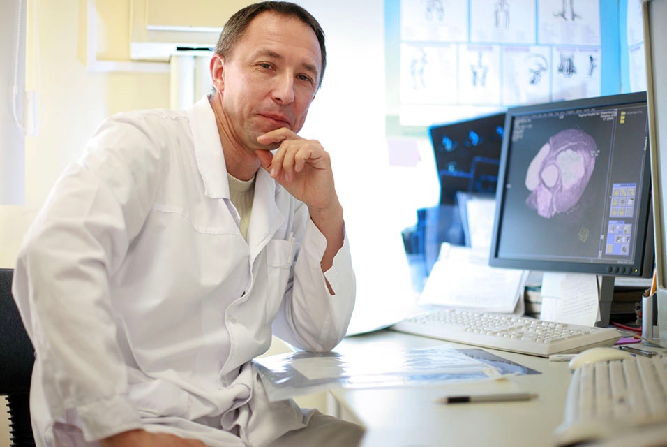 Docteur posant à un bureau devant un ordinateur