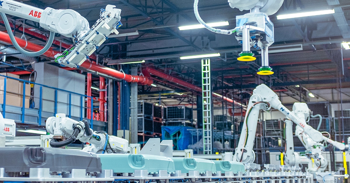 A series of Samsonite suitcases are being assembled on a production line by large ABB robots.