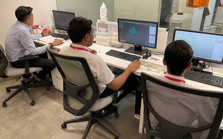 Three Shree Rapid Technologies employees in Mumbai, India working on computers
