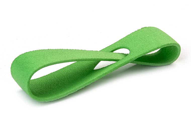Eine grüne 3D-gedruckte Schlaufe aus PA 12, die durch Lasersintern hergestellt wurde und eine farbige Oberfläche aufweist.