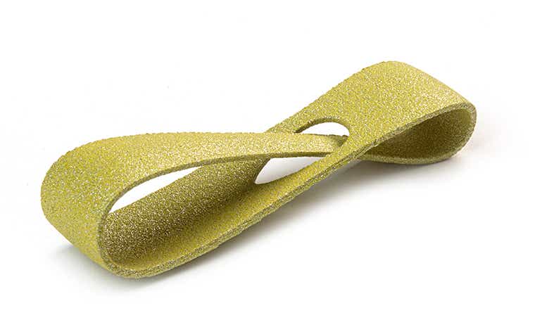 A glittering yellow 3D-printed loop made from PA-AF (aluminum filled) using laser sintering, with a color-dyed finish.