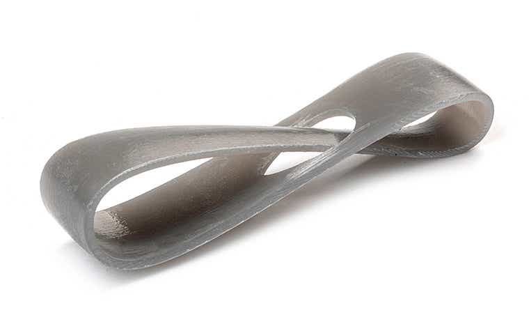 Un anello grigio chiaro stampato in 3D con Tusk Somos SolidGrey 3000 mediante stereolitografia, rifinito rimuovendo tutti i segni di supporto.
