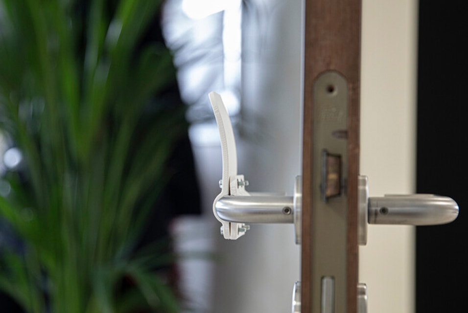 Side view of a 3D-printed, hands-free door opener on a door handle