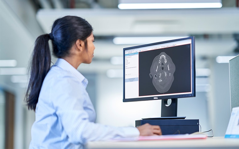Professionnel de la santé regardant un ordinateur avec un logiciel médical