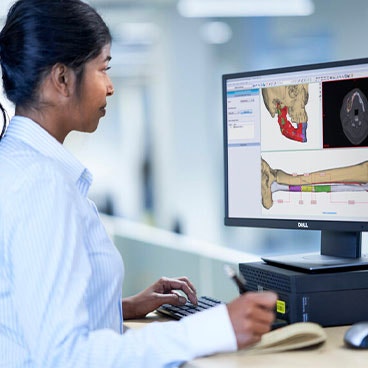 Woman sitting at a computer using medical planning software