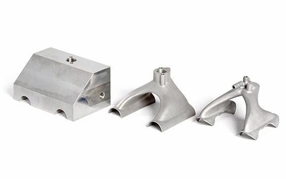 Side-by-side comparison of a suction gripper to be used on production lines. One on the left is bulkier and created with conventional manufacturing methods, and the ones in the center and on the right are sleek and made with 3D printing.