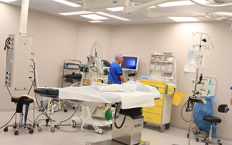 A surgeon looks over her shoulder in an empty operating theater 