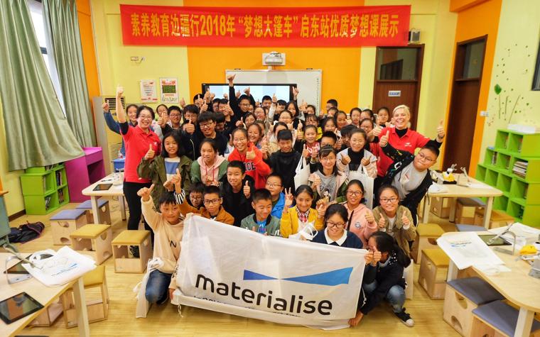 Group photo of school children and teachers holding a Materialise banner