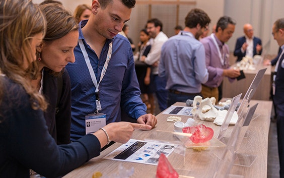 3D printing in medicine course attendees looking at a display of 3D-printed anatomical models 