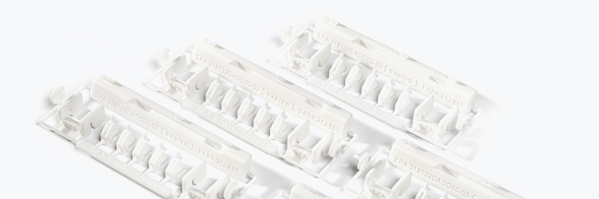 A series of 3D-printed repair kits with EASA 21.J quality labels. The kit contains small white plastic parts made of flame-retardant polyamide, designed by Expleo. These parts are used to replace commonly broken latches on Boeing 737 dado panels. 