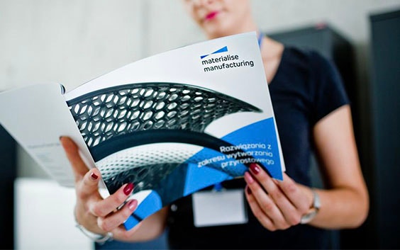 A woman reading a Materialise brochure (wide image)