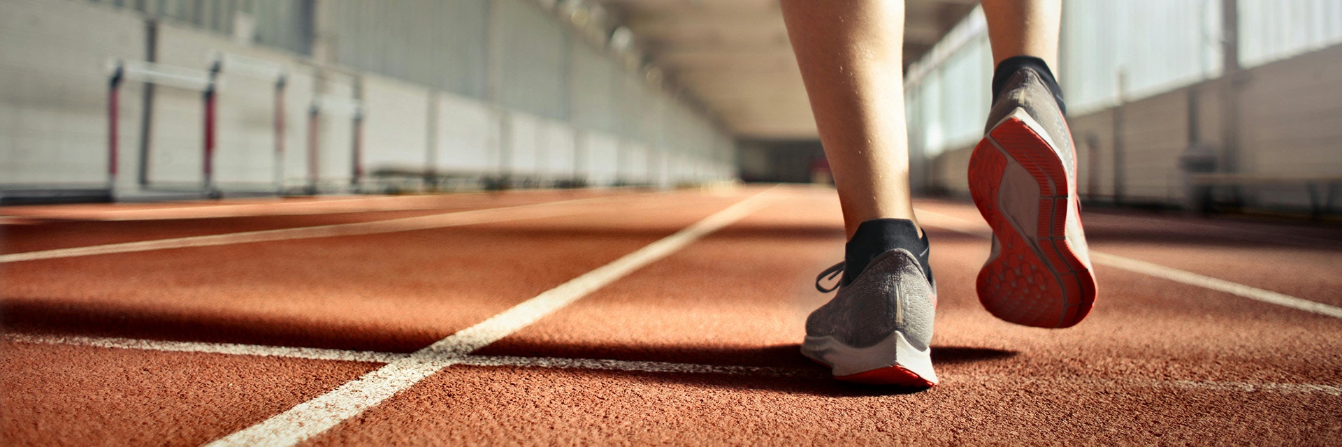 A zoomed in shot of a person's legs, running on an athletics track.
