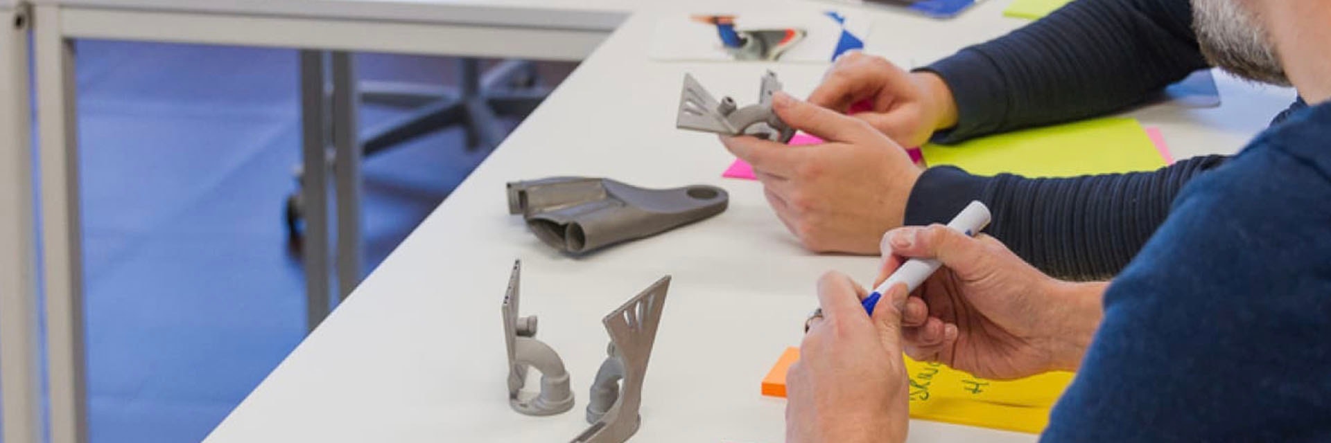 Experten analysieren 3D-gedruckte Metallteile auf einem Schreibtisch