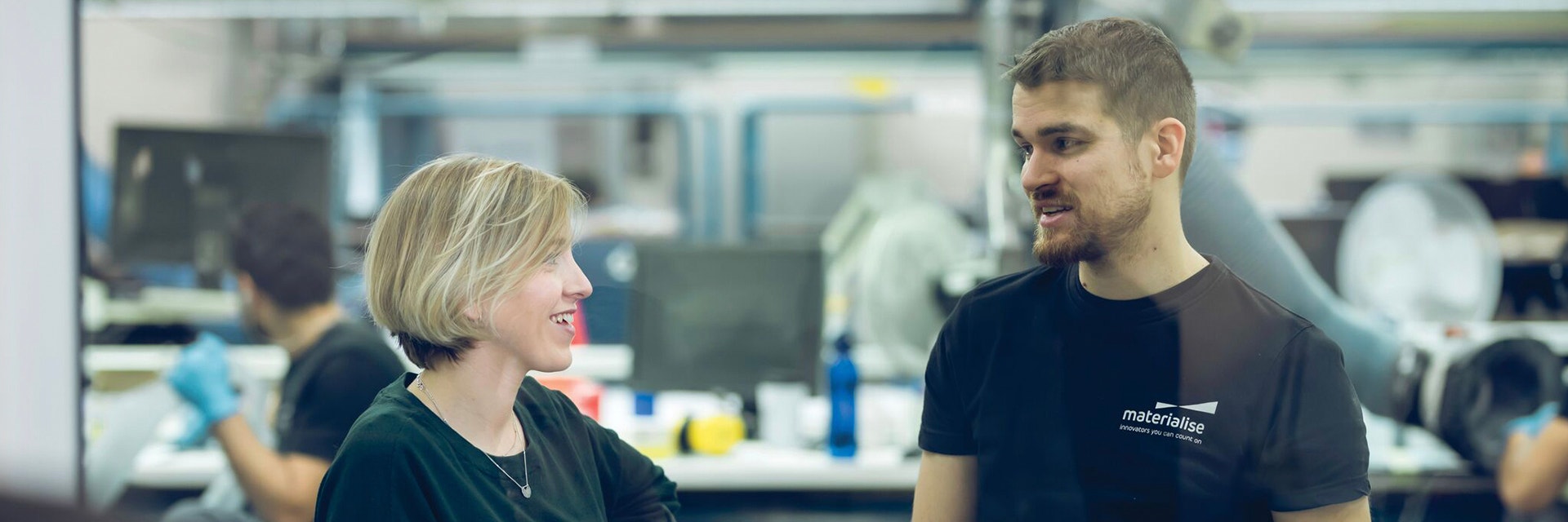Materialise employees talking in a 3D printing factory